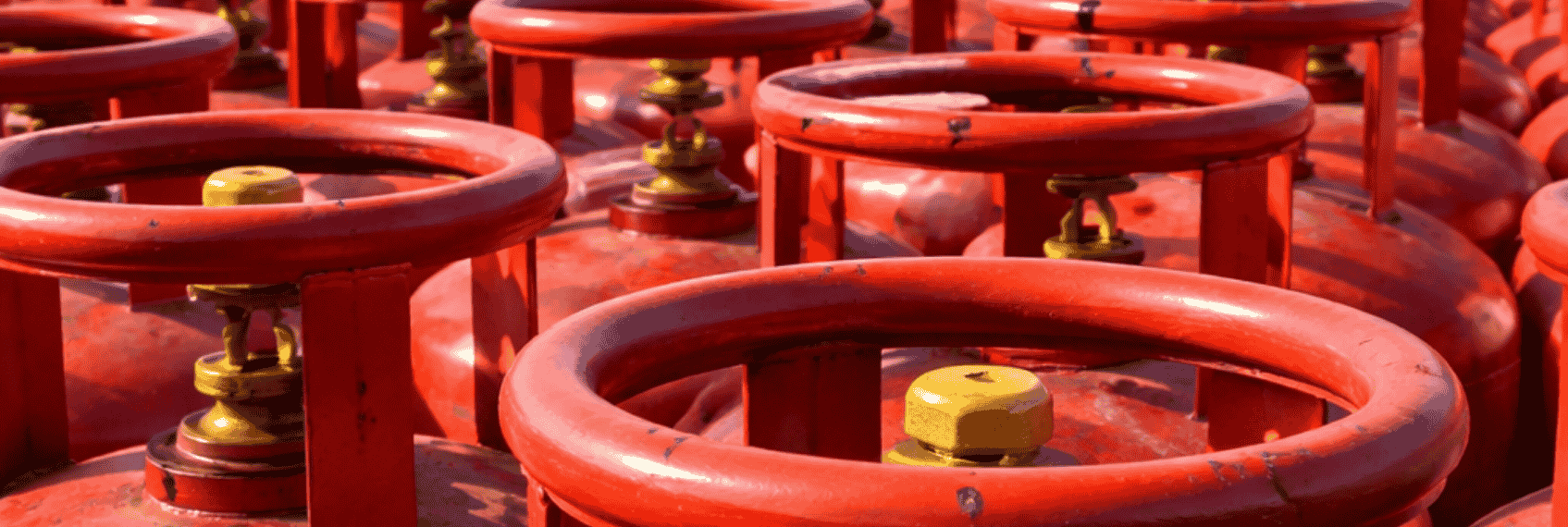 LPG cylinders at port with cargo ships highlighting stable supply via Strait of Hormuz